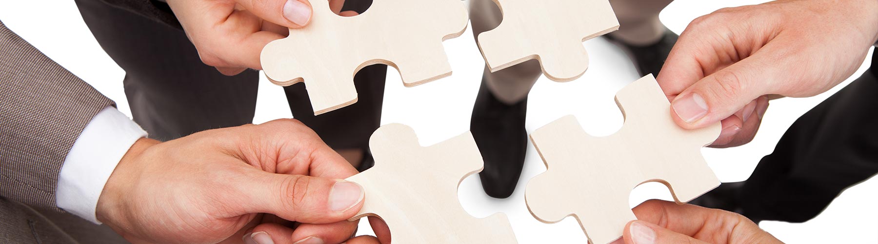 four people holding puzzle pieces together
